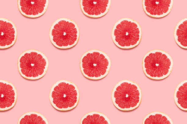 tranches de pamplemousse tropical seamless pattern sur fond rose concept d’été minimal. - grapefruit fruit freshness pink photos et images de collection