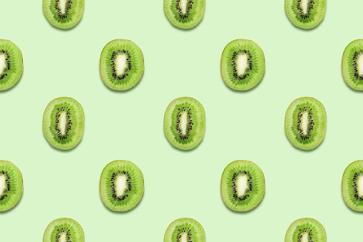 Kiwi slices. Tropical seamless pattern on green background. Minimal summer concept. Flat lay, trendy juicy color.