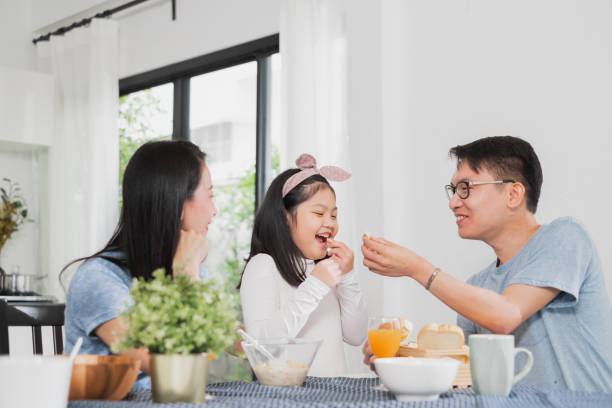 istock Asian family happy enjoy having breakfast on table in kitchen 1155031166
