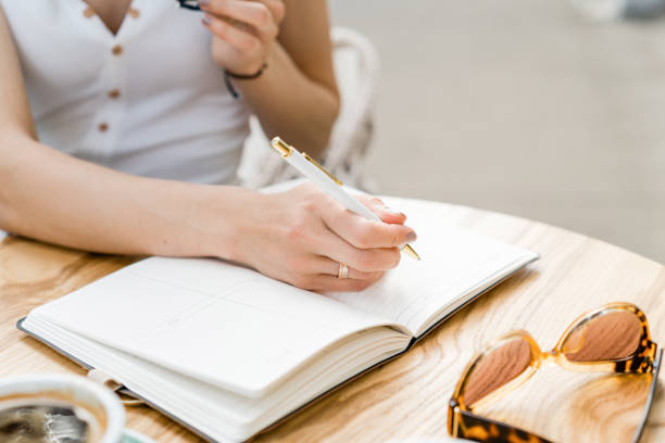 istock Business woman writing in her diary a summer cafe 1155034917