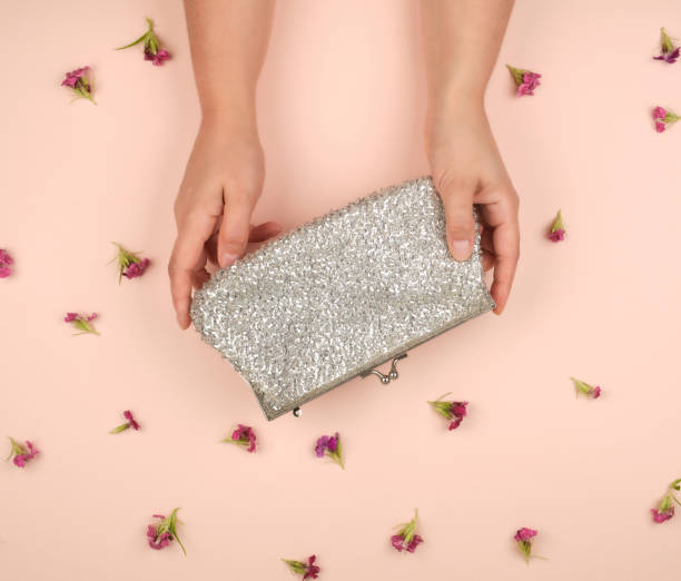 istock women's hands hold a silver clutch 1155035350