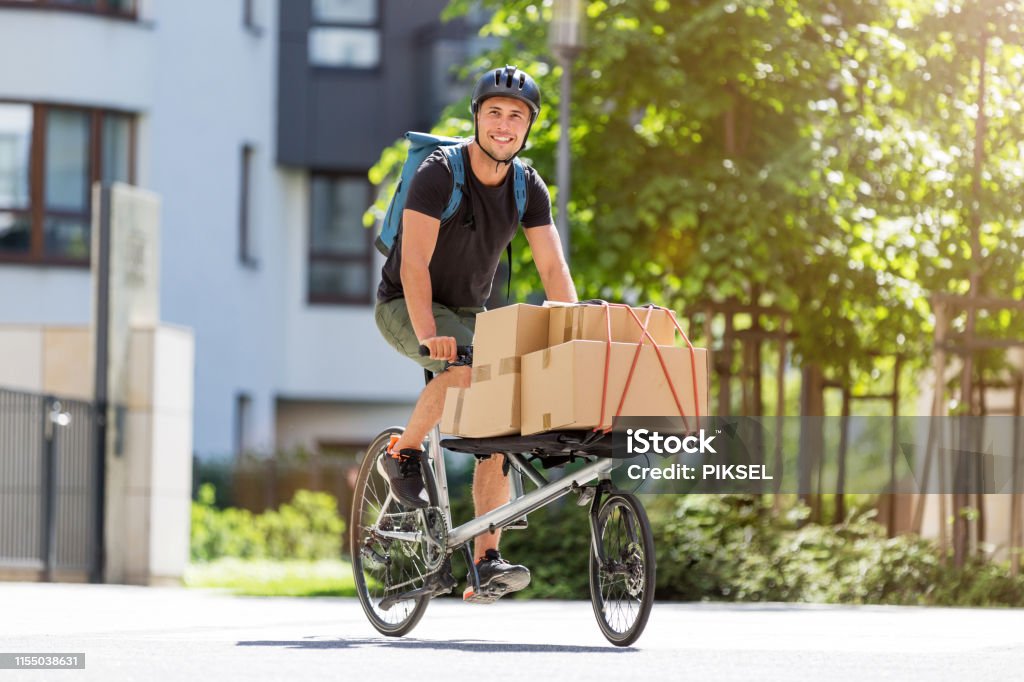 Bike courier making a delivery Bicycle messenger making a delivery on a cargo bike Cargo Bike Stock Photo
