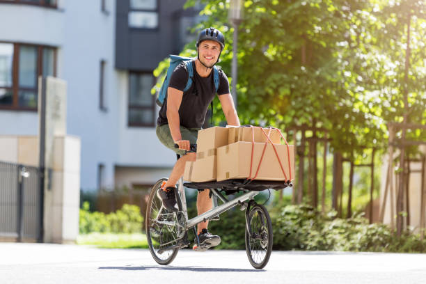 Bike courier making a delivery Bicycle messenger making a delivery on a cargo bike cargo bike photos stock pictures, royalty-free photos & images