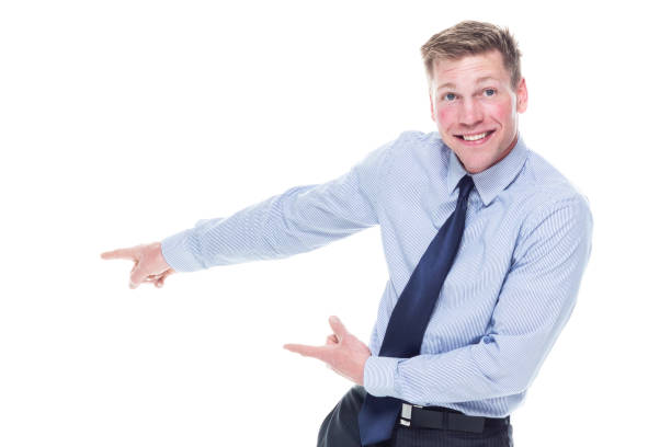 Surprised young guy with funny face in yellow Polo T-shirt pointing to left, white isolated background. Shocked amazed face of young man in yellow T-shirt, portrait of excited man