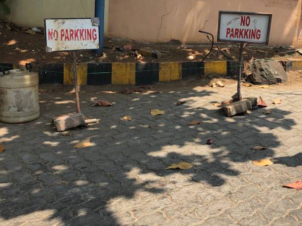 Image of misspelled no parking / parkking sign, red writing on white background, Delhi, India Stock photo showing  a roped off shaded area with handmade sign misspelling no parking / parkking in red writing on a white background, Delhi, India. misspelled stock pictures, royalty-free photos & images