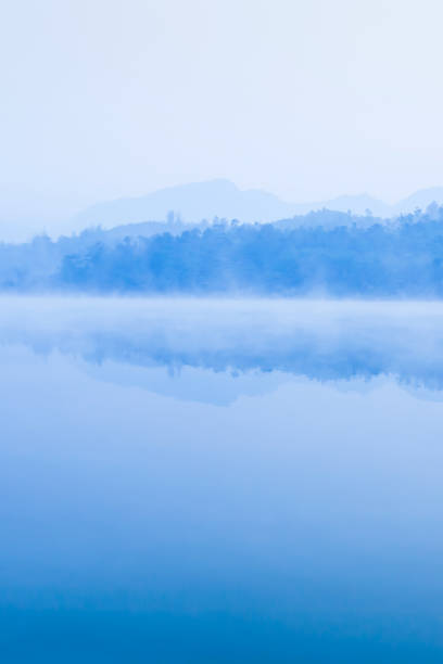 Picturesque scenery of lake on winter morning. Picturesque scenery of lake on winter morning, soft blue misty covers surface of lake and mountain range backdrop, rural scene in Dien Bien Phu, North Vietnam. Soft focus. 2632 stock pictures, royalty-free photos & images