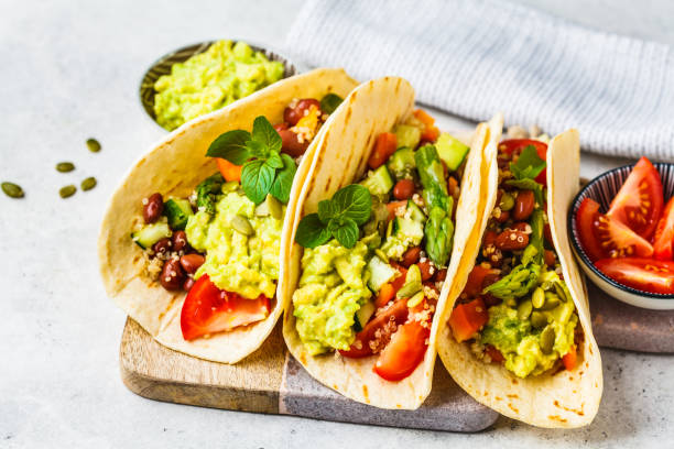 vegane tortillas mit quinoa, spargel, bohnen, gemüse und guacamole. - guacamole avocado mexican culture food stock-fotos und bilder