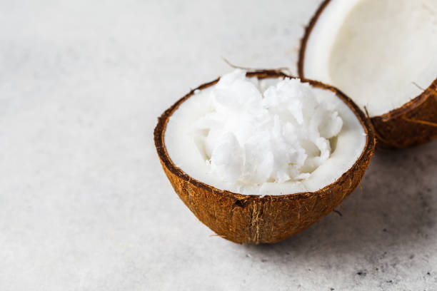 istock Coconut oil in a coconut shell on gray background. 1155045008