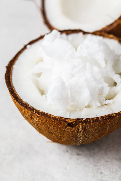 istock Coconut oil in a coconut shell on gray background. 1155045022