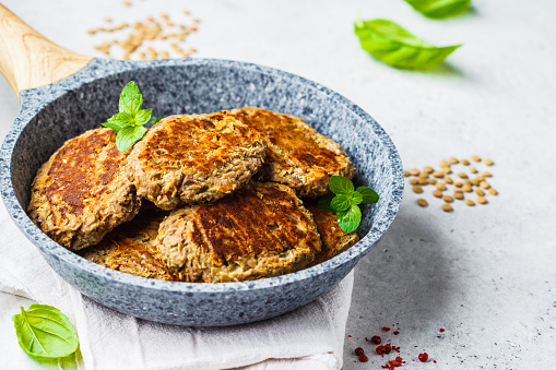 Lentil cutlets in a gray frying pan. Healthy vegan food concept.
