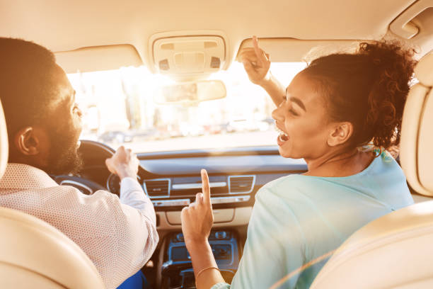 goditi il viaggio. coppia che ascolta musica in auto - driving women rear view sitting foto e immagini stock