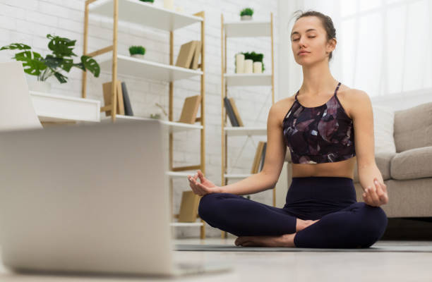 istock Self learning. Woman using laptop to training yoga 1155045971