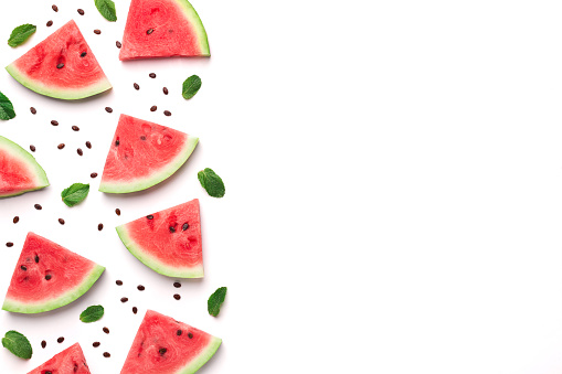 Fresh watermelon slices with seeds and leaves on white background, top view with empty space