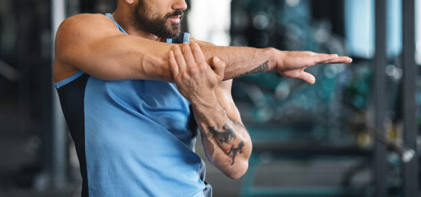 istock Man stretching arms before workout at gym 1155046539