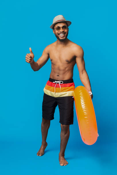istock Friendly african guy showing thumb up, going with inflatable ring 1155046697