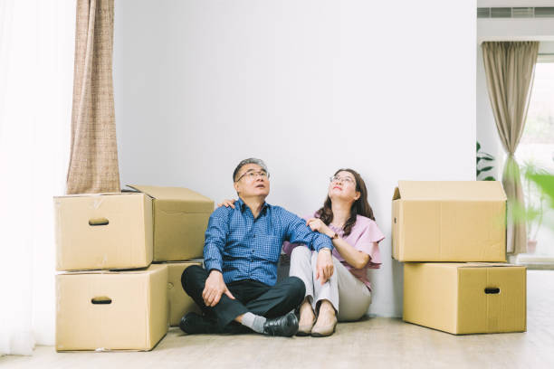 istock Mature couple looking up by cardboard boxes 1155050696
