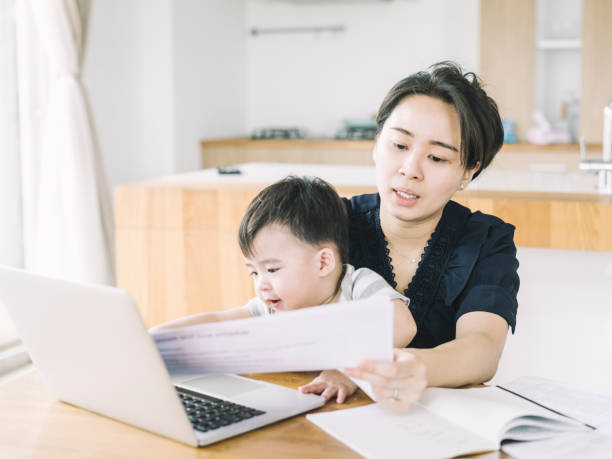 istock Working mother with baby boy examining documents 1155050725