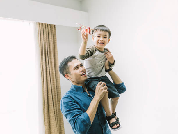 istock Father and son playing with model airplane at home 1155050755