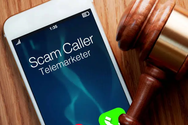 Photo of Telemarketer robocaller scam: legislation for smartphone with gavel