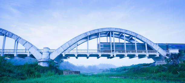 istock Old train passing the Tha Chomphu Bridge in blue misty morning. 1155052120