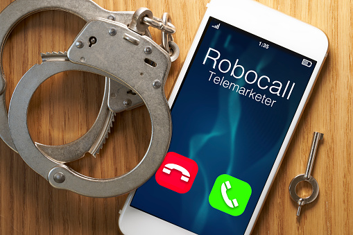 Telemarketer robocaller scam calling smartphone with woman holding telephone in house