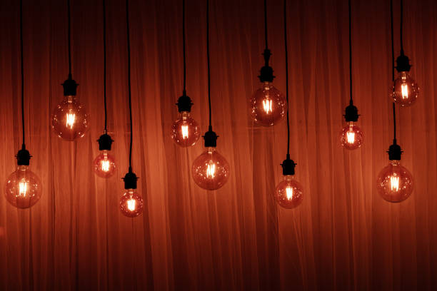 Light bulb on a dark background. Space for your task or message. Garland Light Bulb