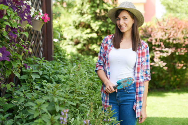 istock Woman standing in back yard with trowel in hand. 1155058570