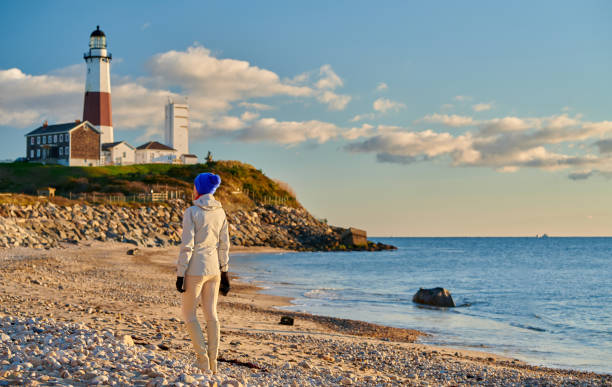 turista da mulher na praia perto do farol de montauk - the hamptons long island lighthouse - fotografias e filmes do acervo