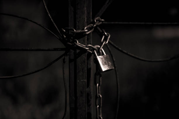 istock Padlock on iron bars of closed gates 1155061687