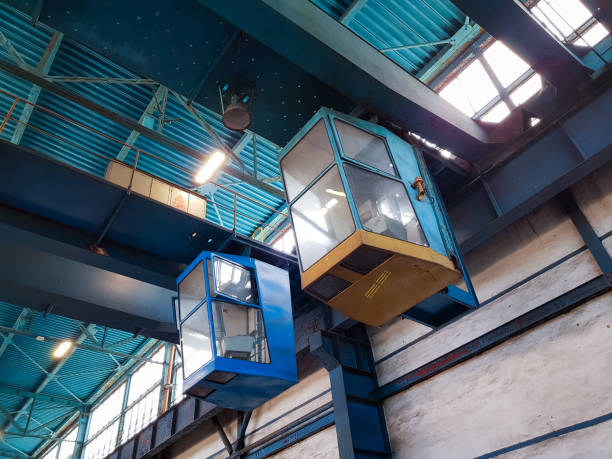istock Looking up to two crane cockpits in a clean looking industry environment 1155061804