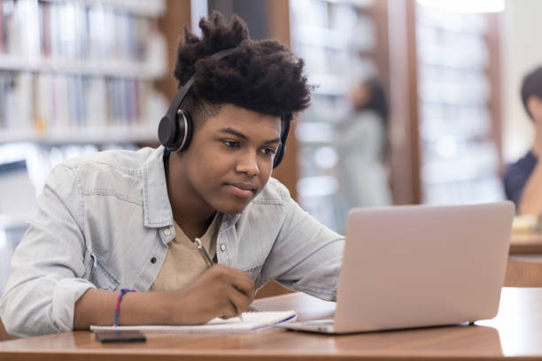 istock Teen boy uses laptop for homework assignment 1155064210
