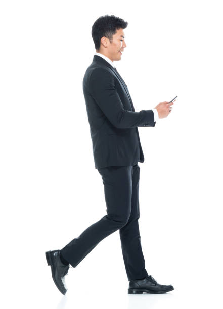 istock Attractive Asian businessman on white background - texting on phone 1155064233