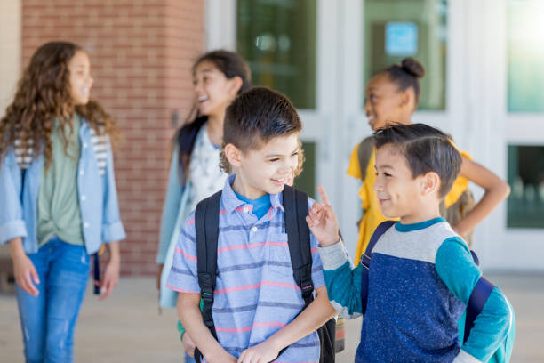 istock Schoolboy laughs with best friend after school 1155064272