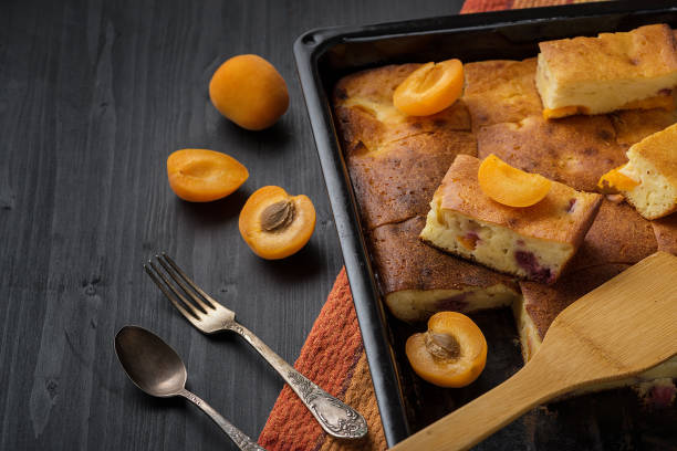 istock Fruit tart and apricots on a black wooden table. 1155064302