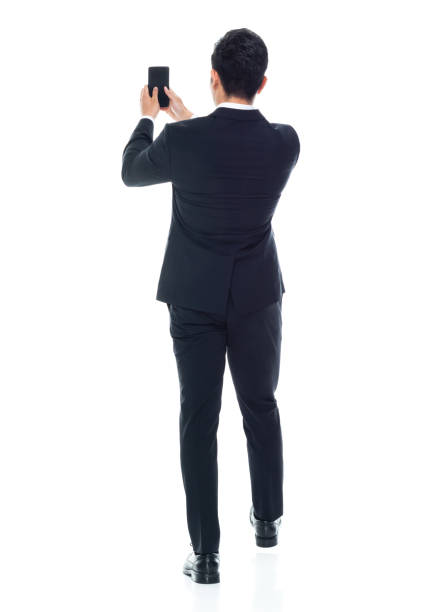 istock Attractive Asian businessman on white background - texting on phone 1155064330