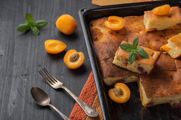 istock Fruit tart and apricots on a black wooden table. 1155070974