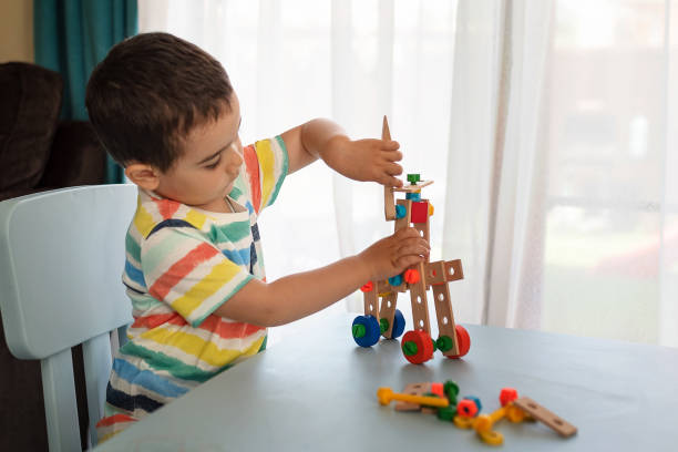 istock Little boy playing with toy tools and building a vehicle 1155071215