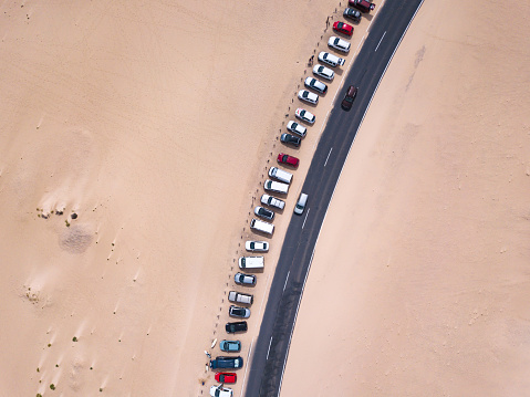 car parking lot near the road in desert, aerial top down view landscape from drone