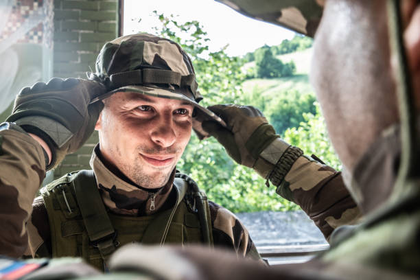 istock Young soldier adjusting uniform hat after the mission operation completed 1155074722