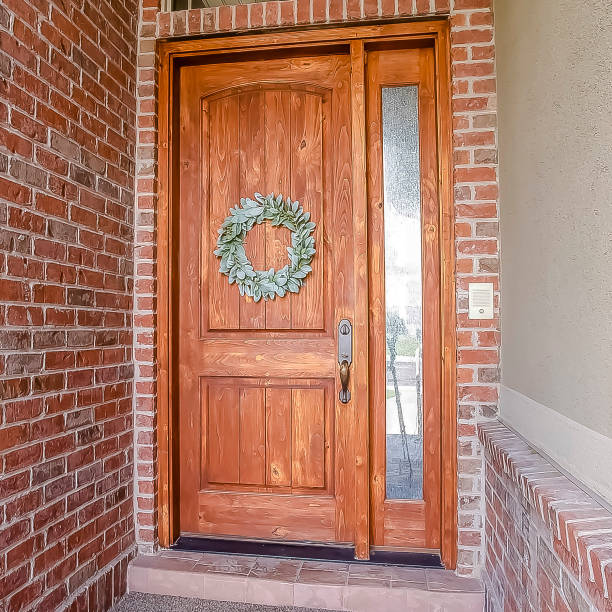 istock Square Rustic wooden door with wreath sidelight and arched transom window 1155076546