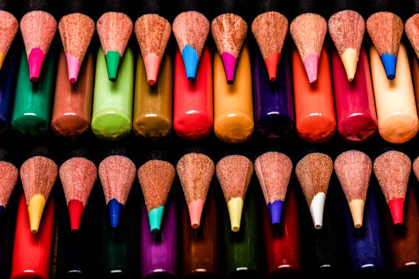 istock A Macro close up of a very OCD stack of colored pencils where every other row is tips and opposing rows are butt ends.  The pencils have black barrels and  1 row of tips in in sharp focus. 1155078337