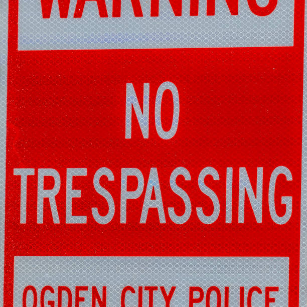 istock Square frame Warning No Trespassing sign against a metal pole and rough brick wall 1155078791