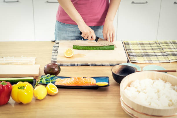 woman preparing sushi in domestic kitchen - sushi japanese culture food domestic kitchen imagens e fotografias de stock