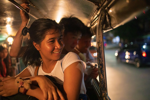Multi-Ethnic Asian friends riding jeepney in Manila at night