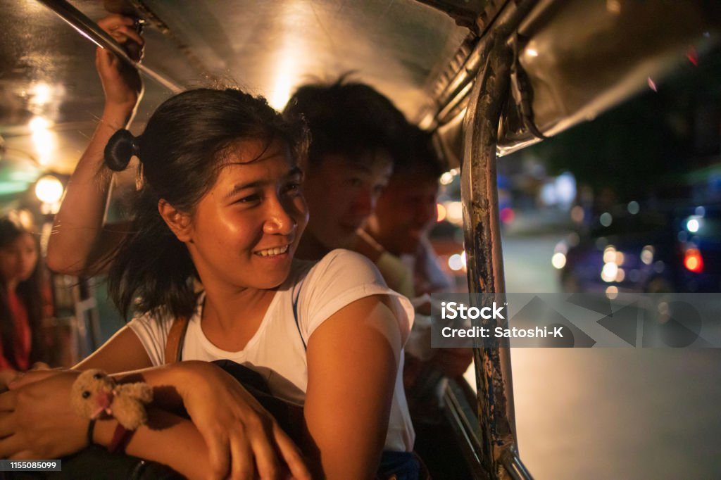 Multi-Ethnic Asian friends riding jeepney in Manila at night Philippines Stock Photo