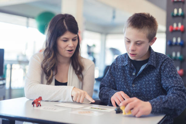 istock Speech therapist works with a young boy 1155090459