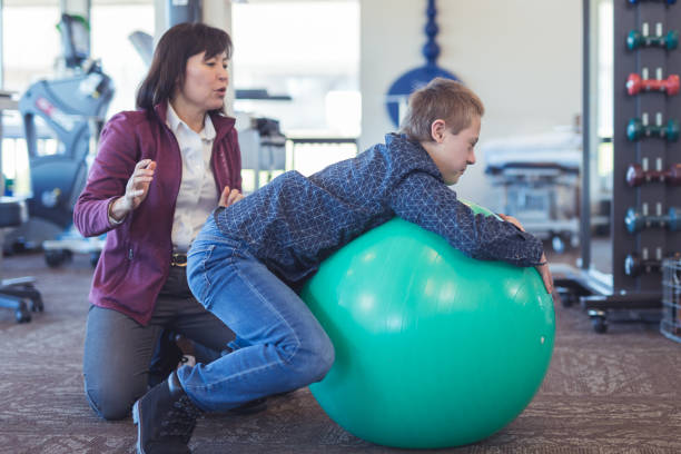 istock A boy does workouts with an occupational therapist at a physiotherapy clinic 1155090483