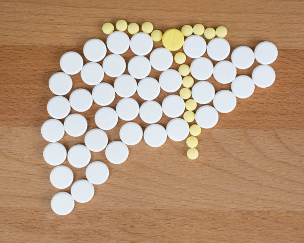 White round oral pills of medicine and yellow tablets drug arranged in liver shape on wooden background.Paracetamol is the most common cause of acute liver failure (ALF).Medical healthcare concept. White round oral pills of medicine and yellow tablets drug arranged in liver shape on wooden background.Paracetamol is the most common cause of acute liver failure (ALF).Medical healthcare concept. liver failure stock pictures, royalty-free photos & images