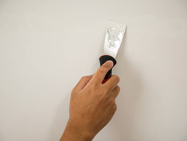 istock Plasterer hand repair crack white wall 1155091668
