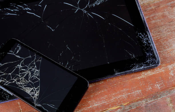 Cracked broken phone and tablet screen closeup Cracked broken phone black touch screen tablet with broken closeup broken digital tablet note pad cracked stock pictures, royalty-free photos & images